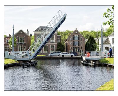 Huizen aan het water met openstaande brug er voor