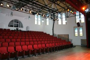 Zaal met rode stoelen in theateropstelling