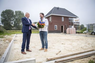 Wethouder Smit overhandigt dhr. Niewold een bos bloemen