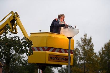 Wethouder Vlieg draait led-lamp in lantaarnpaal 