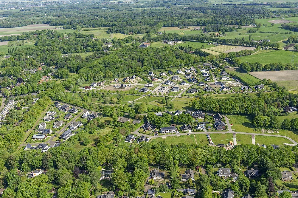 Luchtfoto van Het Eikendal. Villa's staan in een bosrijk gebied.