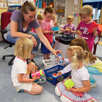 Peuterleidster speelt met kinderen