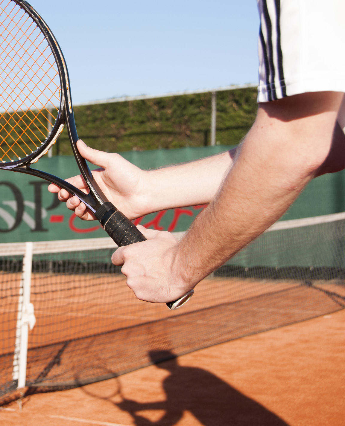 Twee handen die tennisracket vasthouden