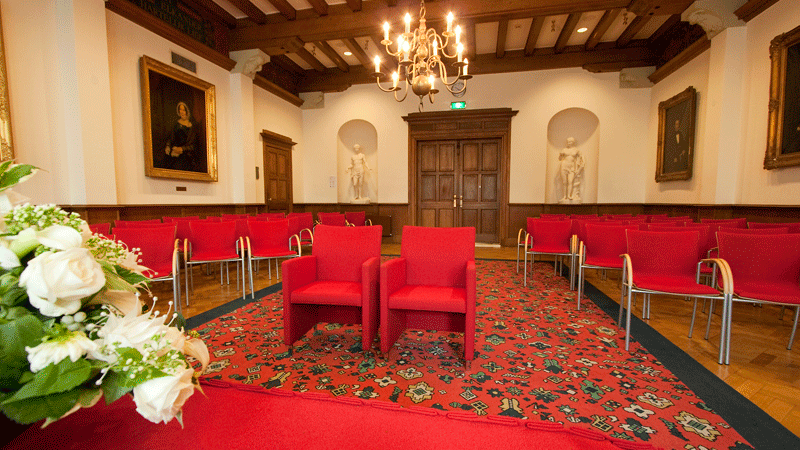 binnenaanzicht trouwlocatie gemeentehuis met rode stoelen
